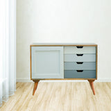 Comme design scandinave composée de 4 tiroirs  et une porte. 